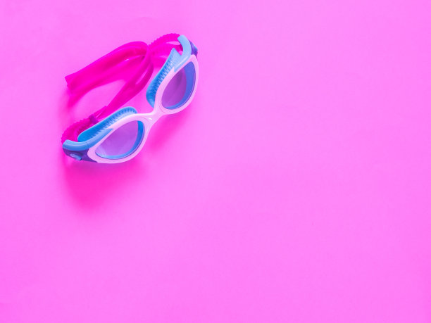 游泳池眼镜在强烈的粉红色背景与复制空间图片下载