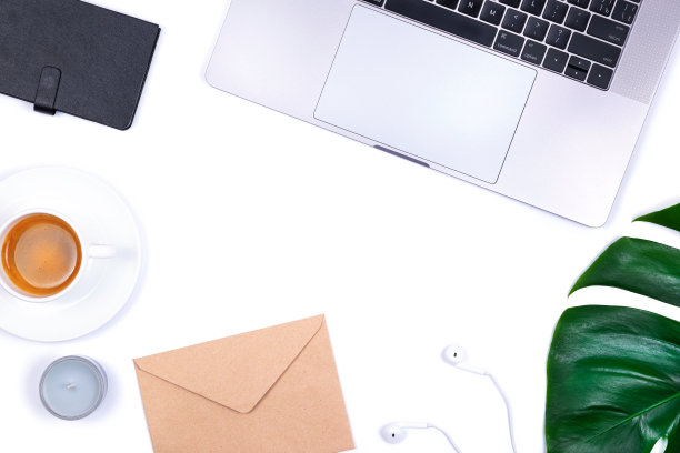 白色背景上的笔记本电脑、热带叶植物、笔记本、蜡烛、耳机和一杯咖啡构成办公空间。图片下载