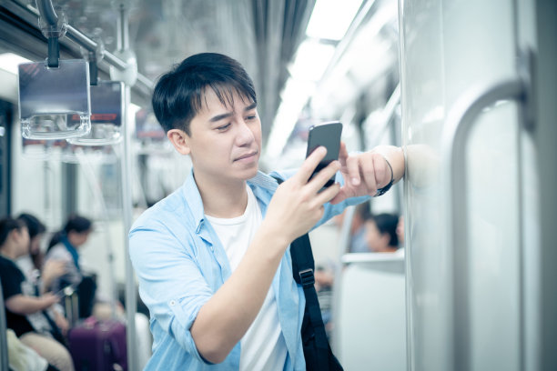 年轻人在地铁上使用智能手机图片下载