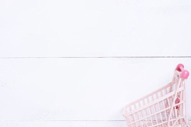 抽象的设计元素，年度销售，购物季节的概念，小手推车与彩色纸袋在白色木制桌子背景，俯视图，平铺图片下载