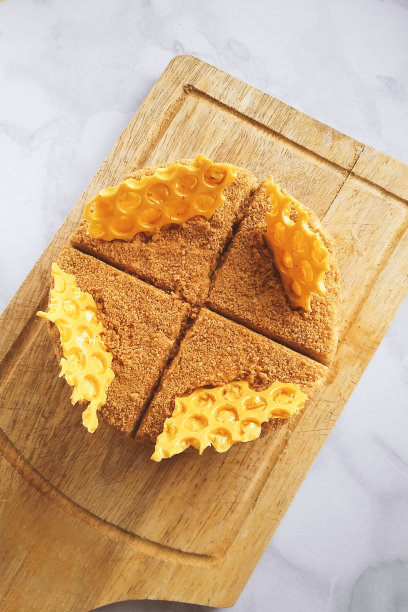 俄罗斯分层蜂蜜蛋糕medovik甜点在木制托盘大理石装饰的巧克力蜂巢和奶油形状的水仙花。生日聚会庆祝，俯视图图片下载