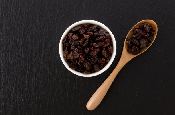 黑石背景的葡萄干碟图片下载