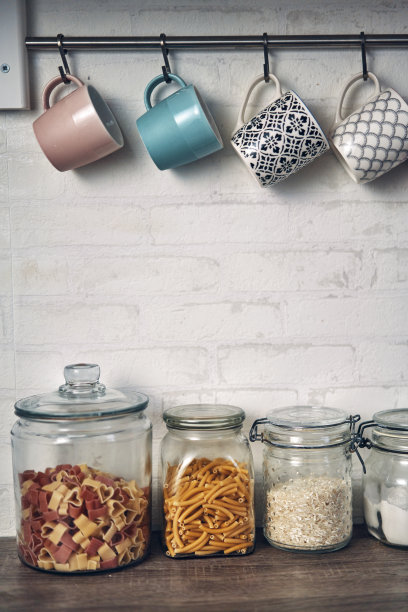 杯子和供应罐面粉，糖和面条在家庭厨房素材图片
