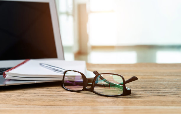 笔记本电脑，桌上放笔和记事本图片下载