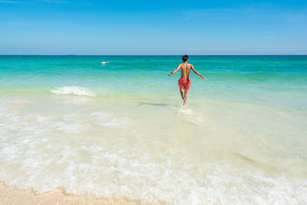 泰国沙美岛奥围海滩。快乐的人冲进碧绿的大海图片下载