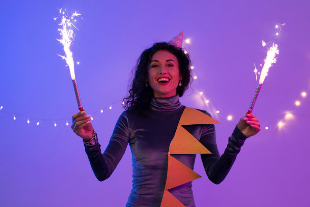 女人拿着节日燃烧的烟火，玩得很开心。新年，生日，假期。图片下载