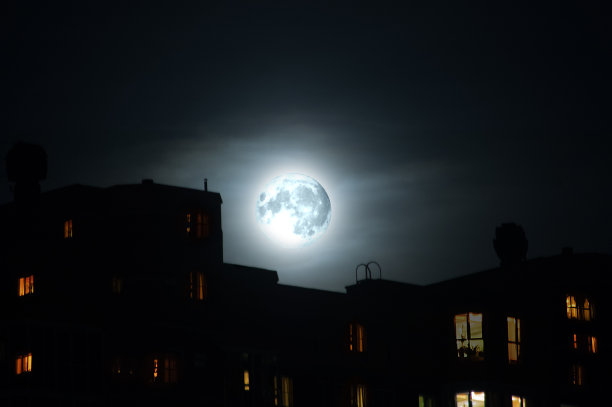 特写月亮在晚上的公寓大楼在城市。城市景观。图片下载