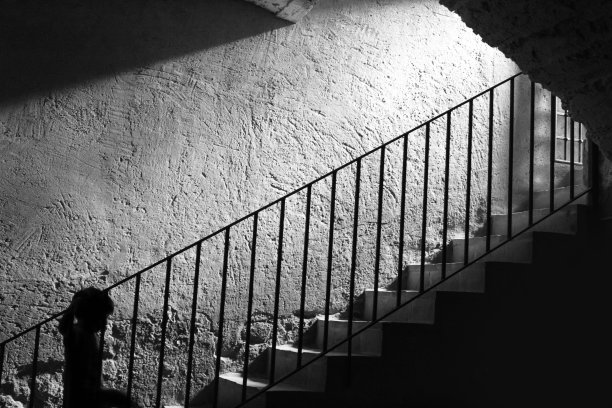 一个男孩爬上背光楼梯的剪影图片下载