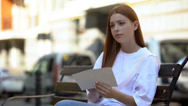 伤心的红发女孩心情抑郁，抱着心爱的照片，爱着图片下载