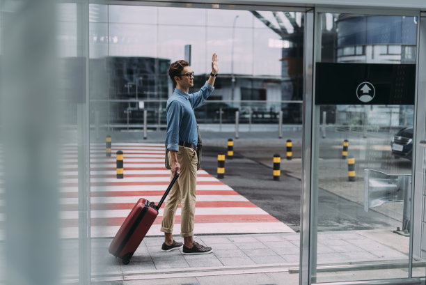 男子向某人挥手后到达机场库存照片图片下载