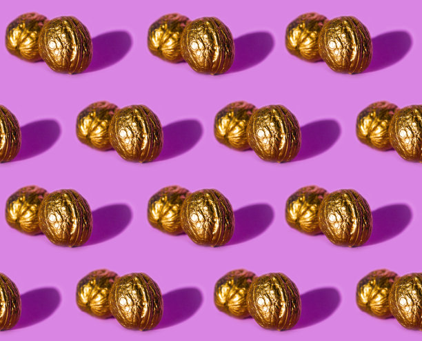 无缝图案与金色核桃在紫色的背景。图片下载