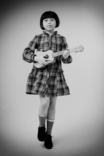 小女孩手拿四弦琴的抽象艺术设计背景，黑白色调，模糊的灯光设计背景图片下载