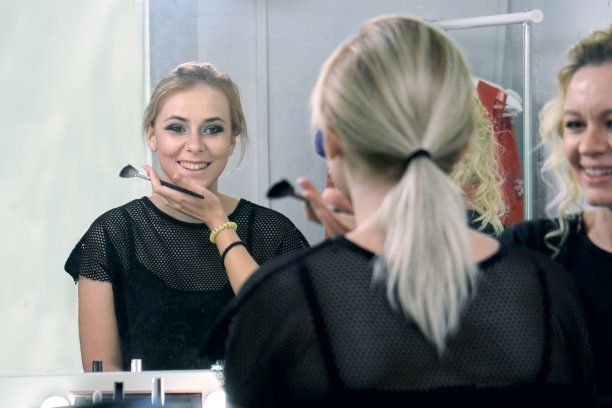 化妆师为一个年轻的金发女郎模特化妆前的照片会议图片下载