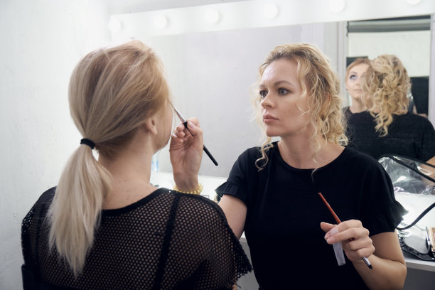 化妆师在为一个年轻的模特化妆前的照片会议图片下载
