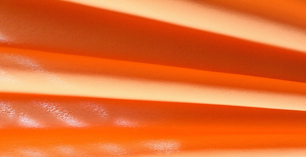 图片纹理，背景橙色真丝面料。它有一个奇妙的光泽与轻微的颜色变化，使面料看起来像条。理想的添加一个触摸的豪华装饰项目图片下载