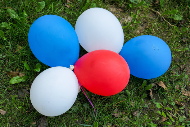 白色，蓝色和红色的气球在绿色的草地上，颜色的法国或俄罗斯国旗图片下载