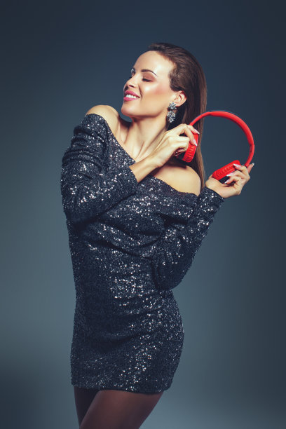 年轻的女明星拿着耳机跳舞，闭着眼睛图片下载