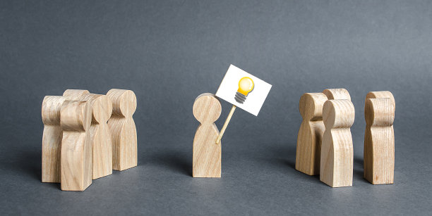 一个人拿着一张画着点子灯泡的海报指的是一群人。提出一个新的想法和选择，重新看待问题并找到解决方案的概念。雄心壮志图片下载