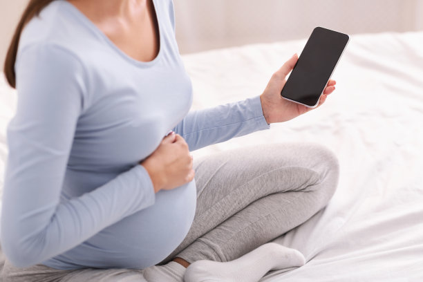 在家拿空白屏幕手机的孕妇图片下载