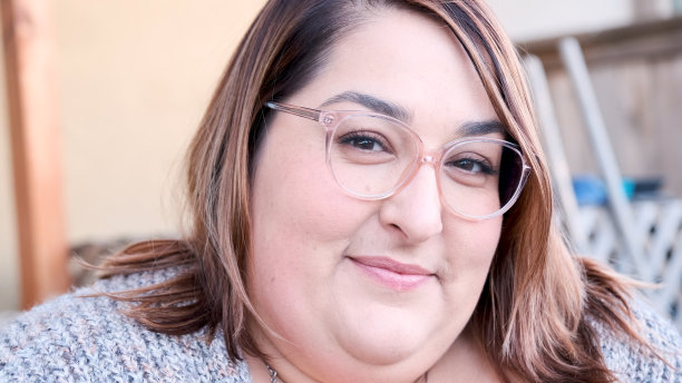 微笑的中年妇女看着自家后院的摄像机图片下载