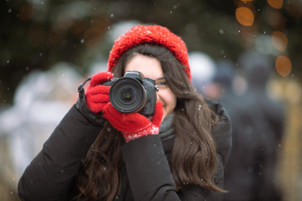 女摄影师与专业相机拍摄室外在冬天的圣诞树背景图片下载