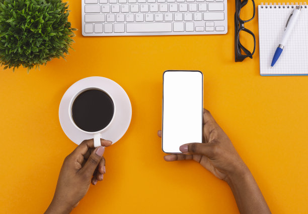 在工作场所拿着空白手机喝咖啡的黑人女性图片下载