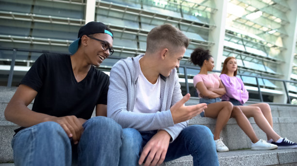 两个男生坐在女同学旁边大笑，青春闲话图片下载