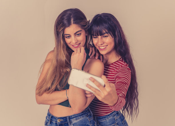 两个美丽快乐的女朋友在社交媒体上自拍或录制视频。两个美女在一起玩的自拍。人、技术、友谊和社交媒体概念。图片下载