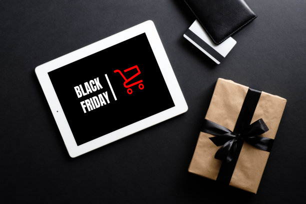 黑色星期五折扣概念。平板与标志“黑色星期五”，礼盒，信用卡在黑色背景图片下载