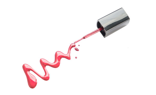 将指甲油和刷子洒在白色背景上。几滴液体指甲油。图片下载