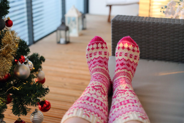 穿着羊毛袜子的女人在阳台上享受圣诞假期图片下载