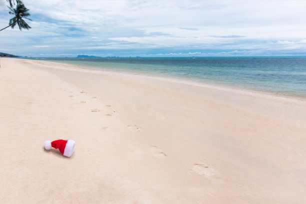 圣诞老人的圣诞帽在沙滩上的热带海滩。假日热带夏季概念。扔帽子图片下载