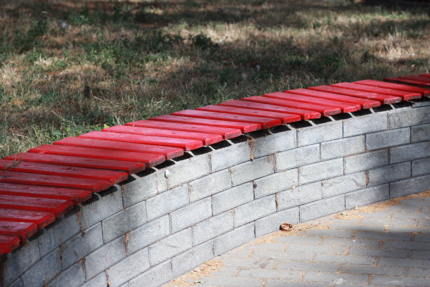 阳光下的红色木质长椅图片下载