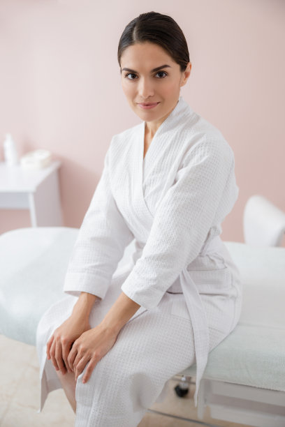 美丽的年轻女子坐在水疗沙龙的躺椅上图片下载