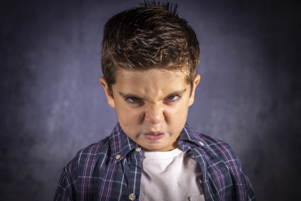 愤怒的孩子。一个表情愤怒的小男孩。图片下载