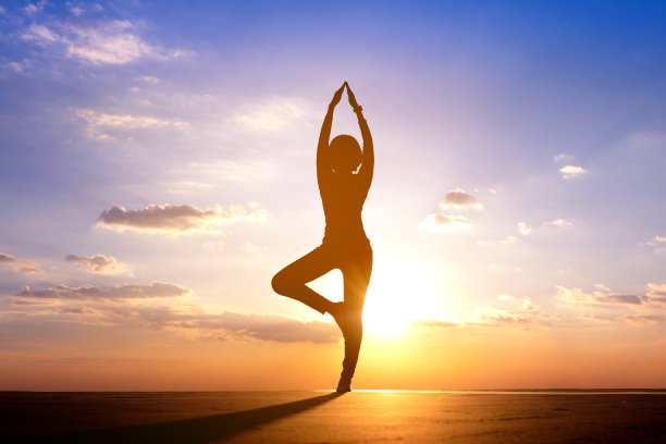 女人早上在山上练瑜伽。美丽的天空日出背景图片下载