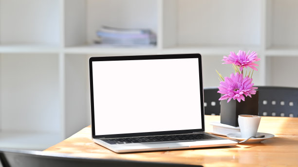 舒适的工作空间，笔记本电脑，咖啡和鲜花。图片下载