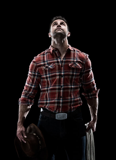 腰部以上/一人只/一人的成年人英俊的人白人青年/男性牛仔站在黑色背景穿着伐木工衬衫/格子衬衫/纽扣衬衫/衬衫/牛仔裤/裤子/牛仔帽/帽子和使用绳子图片下载