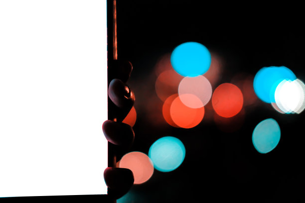 手持移动智能手机与散景夜灯图片下载