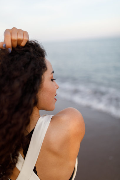 年轻女子在海滩上欣赏日落图片下载