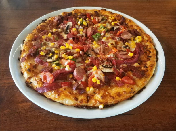 桌子上的白盘子里装着一整块披萨图片下载