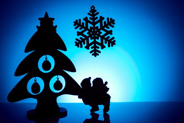 蓝色的背景上是圣诞树、雪花和孩子的剪影图片下载