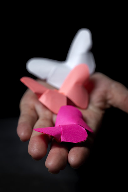 女人的手拿着一个折纸人物图片下载