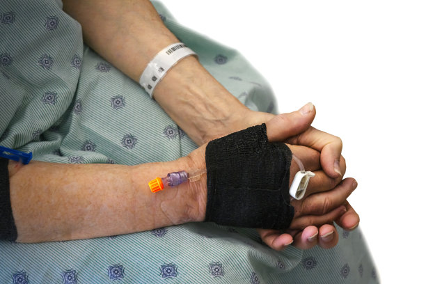 一个男性病人的手与静脉注射，坐在医院的床上，等待护士的特写。孤立在白色背景上。图片下载