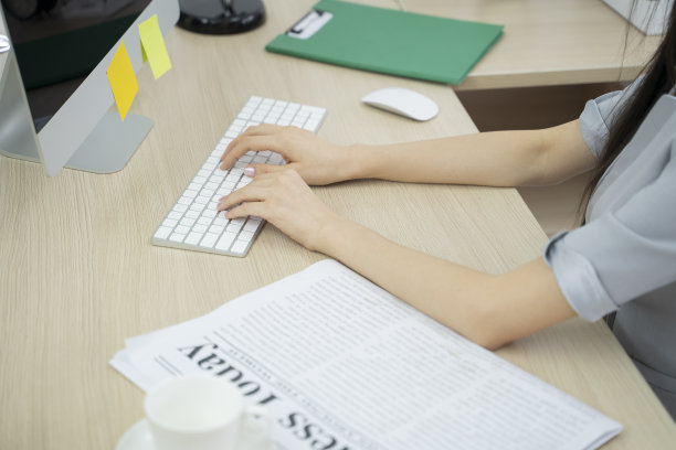 一位迷人的亚洲商务女性在她的工作站电脑上工作的照片。图片下载