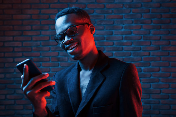 未来的霓虹灯照明。年轻的非裔美国人在演播室里图片下载