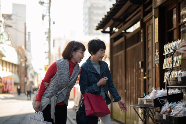 老年妇女和她的中年女儿在旅游景点散步图片下载