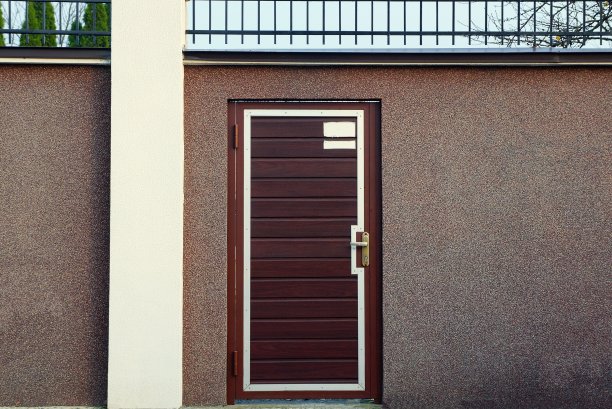 混凝土围墙上的棕色紧闭的木门图片下载