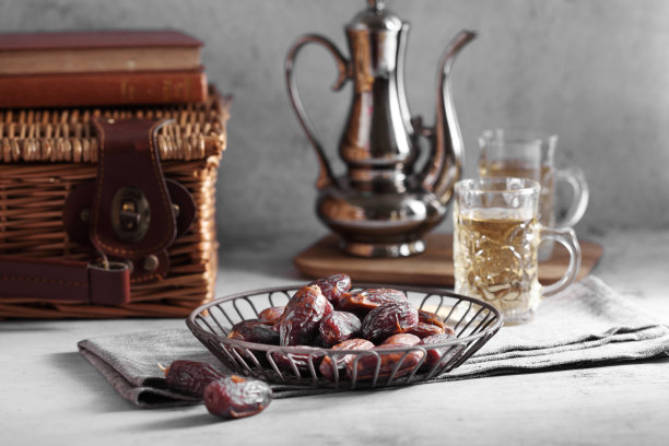 红枣水果和阿拉伯茶在白色的混凝土背景与空白的文字，红枣水果在白色的背景图片下载