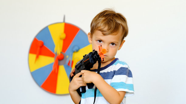 一个小男孩在玩玩具枪图片下载